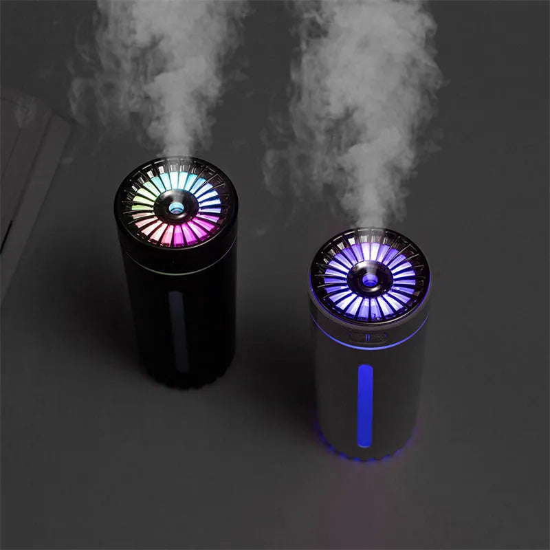 Compact black wireless humidifier with colourful LED lights sitting in car cup holder