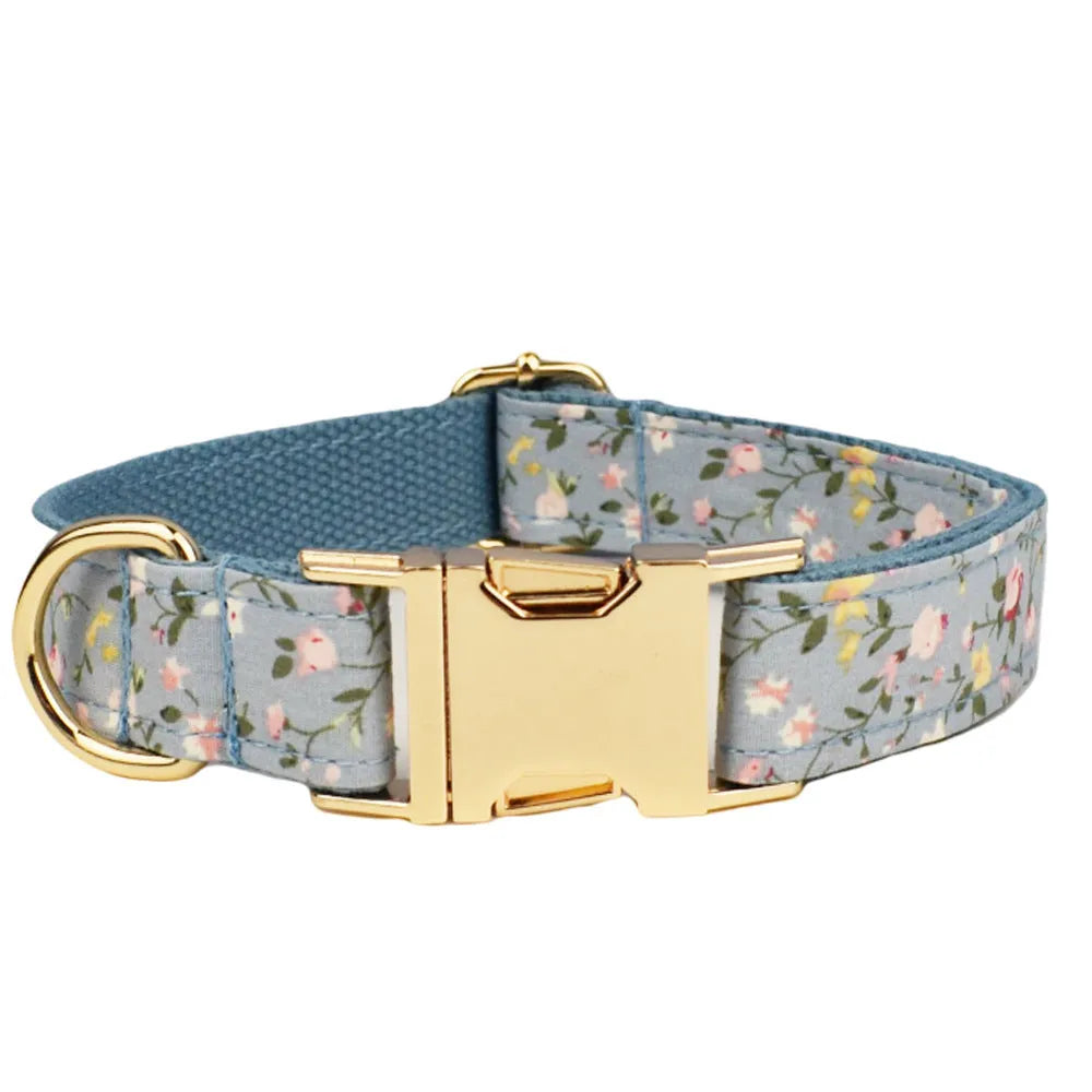 Blue floral patterned cloth dog collar with matching leash and vest set on a white background.