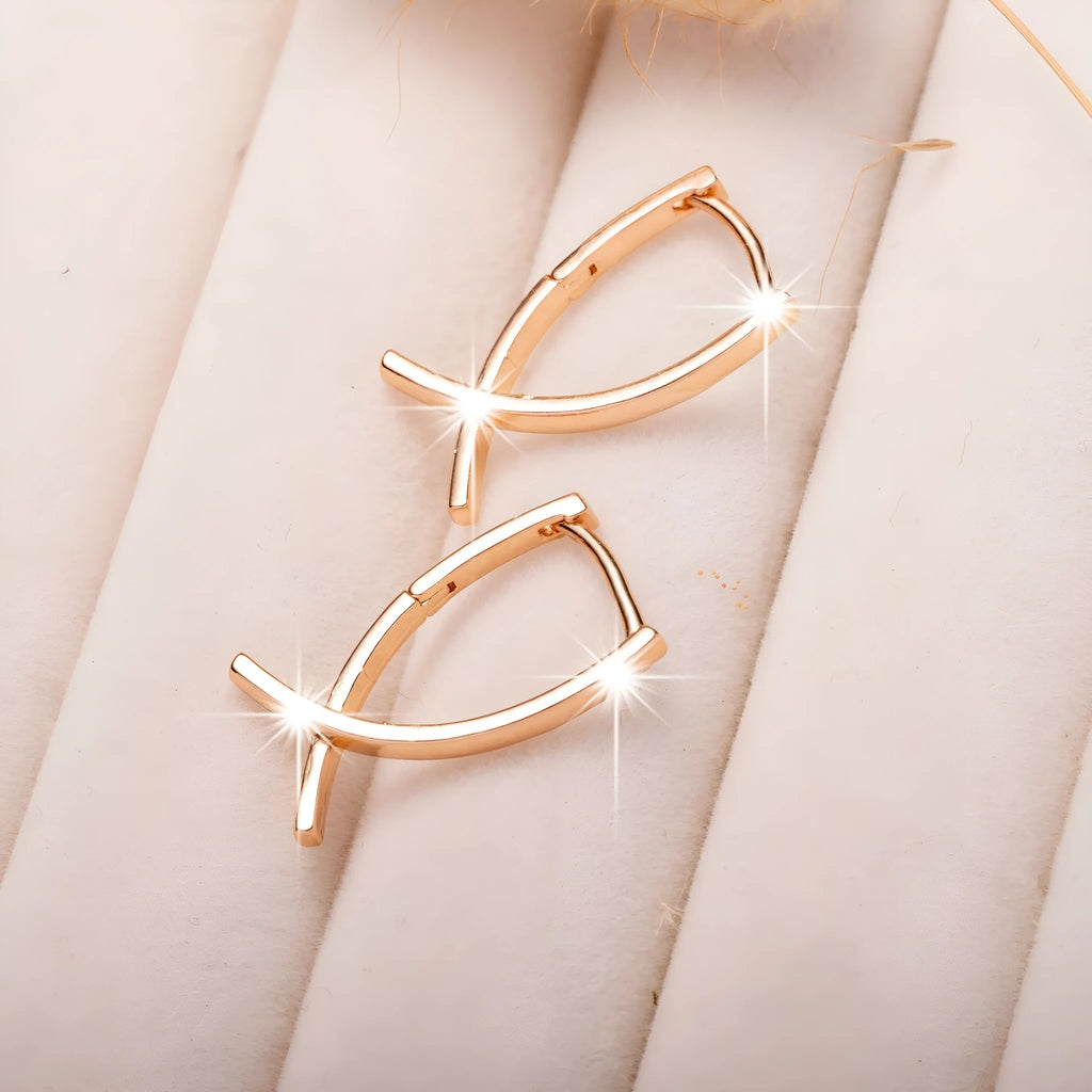 Single pair of rose gold cross shaped earrings made from copper with light luxury design
