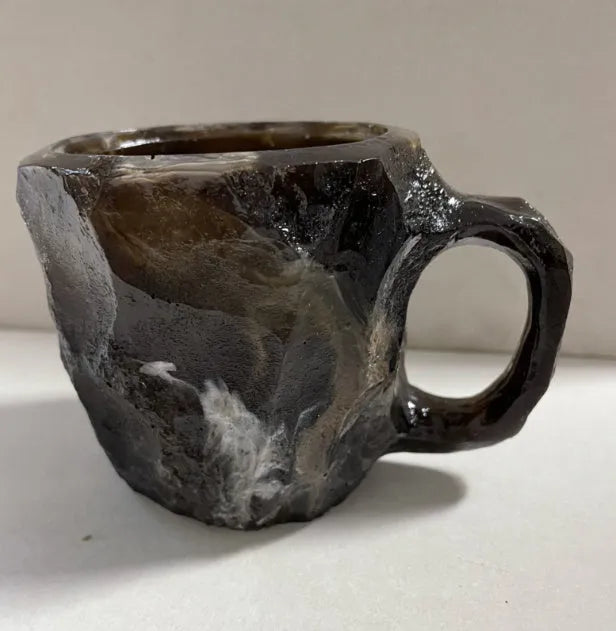Purple and blue resin coffee mug with crystal texture and handle on wooden table