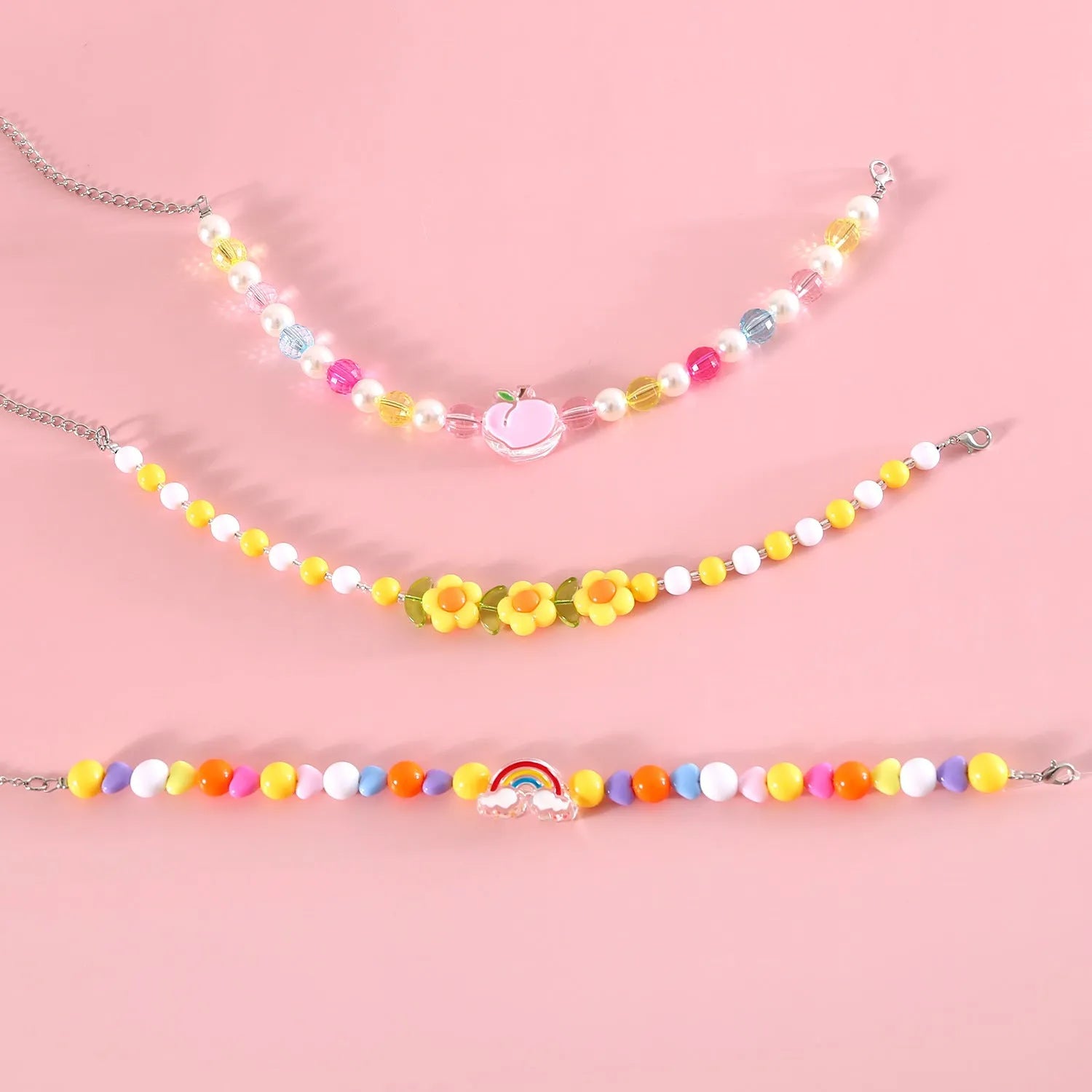 Colourful plastic bead pet necklace for a cat or dog in peach, rainbow, or small flower pattern.