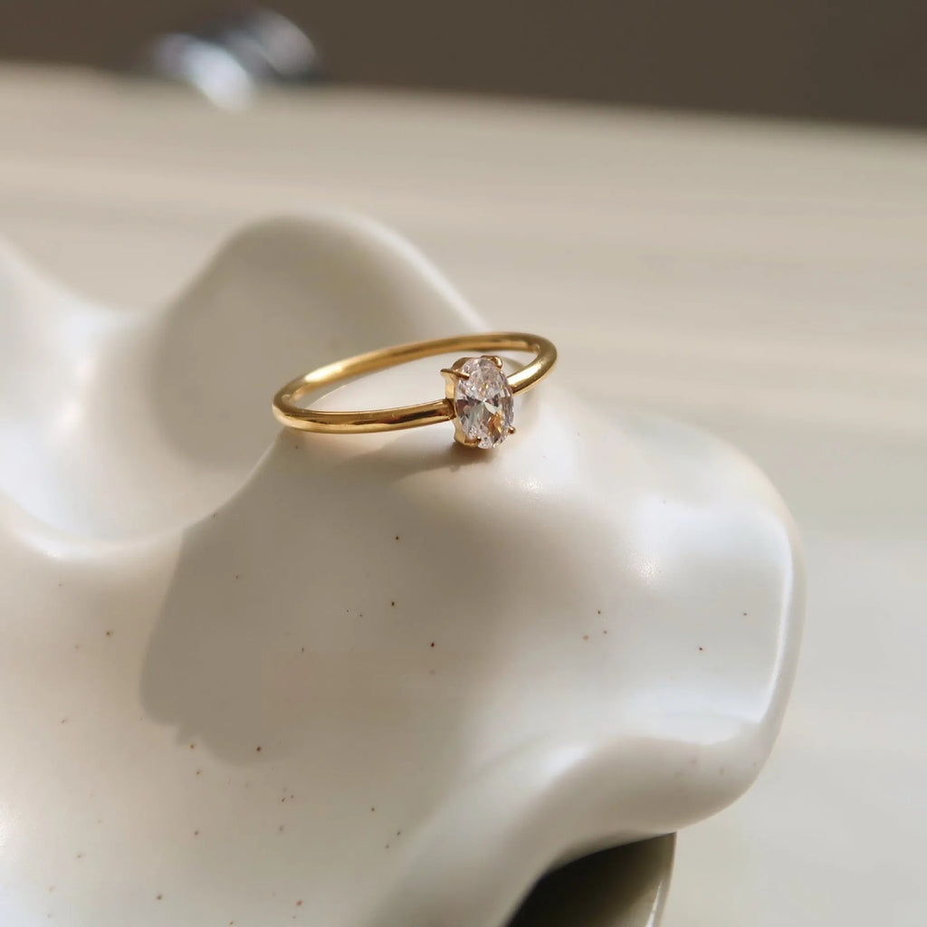 Gold electroplated stainless steel women's ring with heart design in oval shape on finger