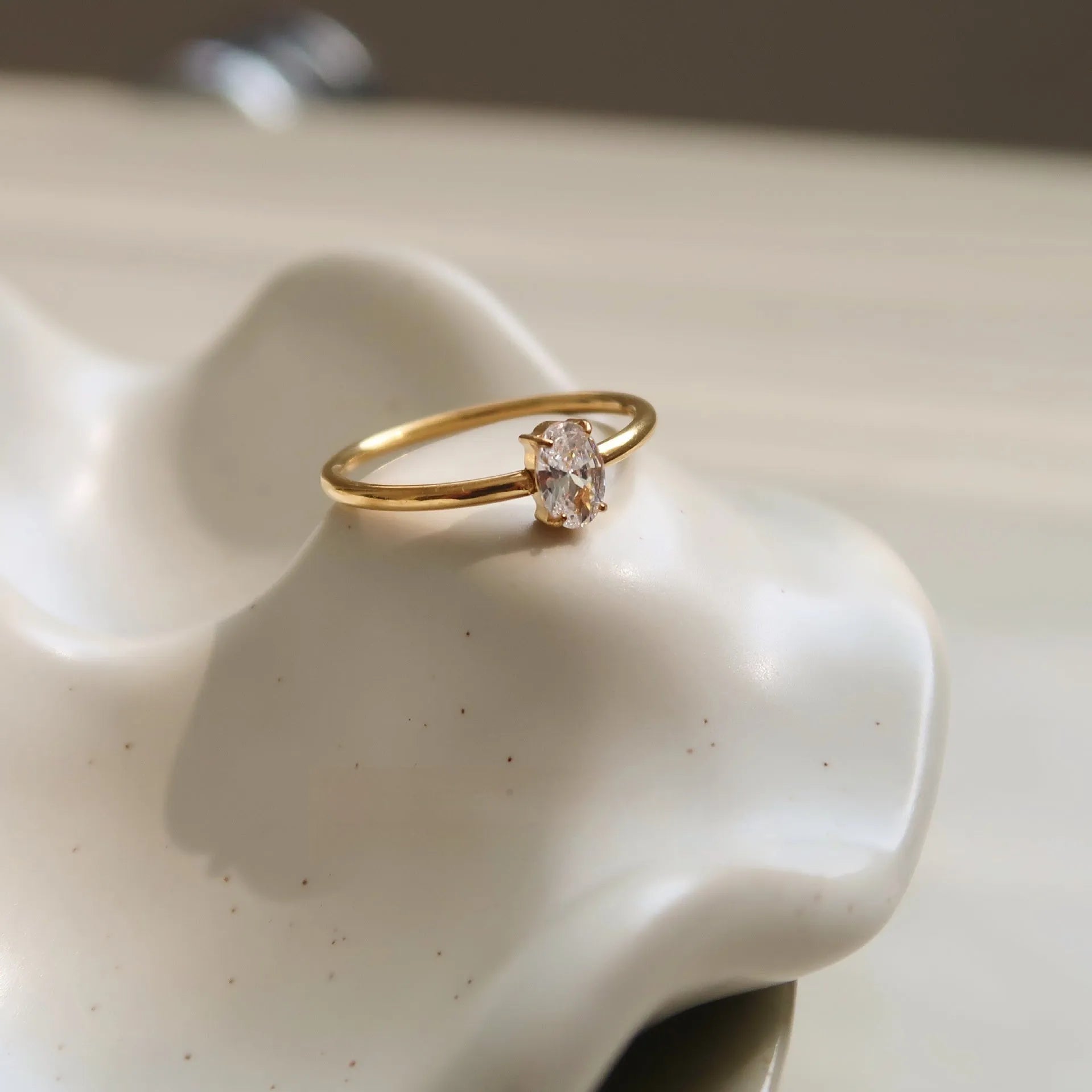 Gold electroplated stainless steel women's ring with heart design in oval shape on finger