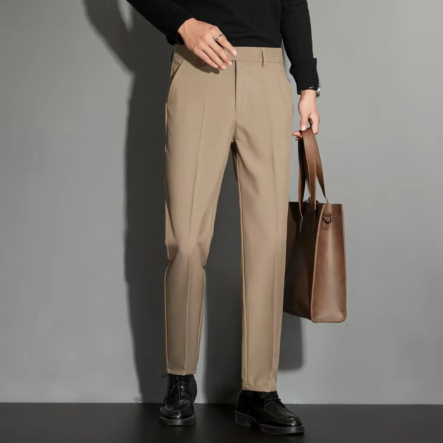 Man wearing apricot-coloured straight-leg suit trousers with an ankle-length draping effect.