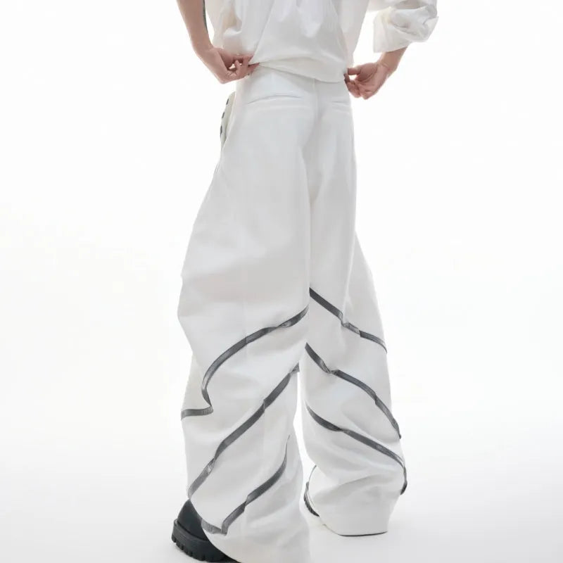 Men's black trousers with three-dimensional cutting and metal rivet pleats on a white background.