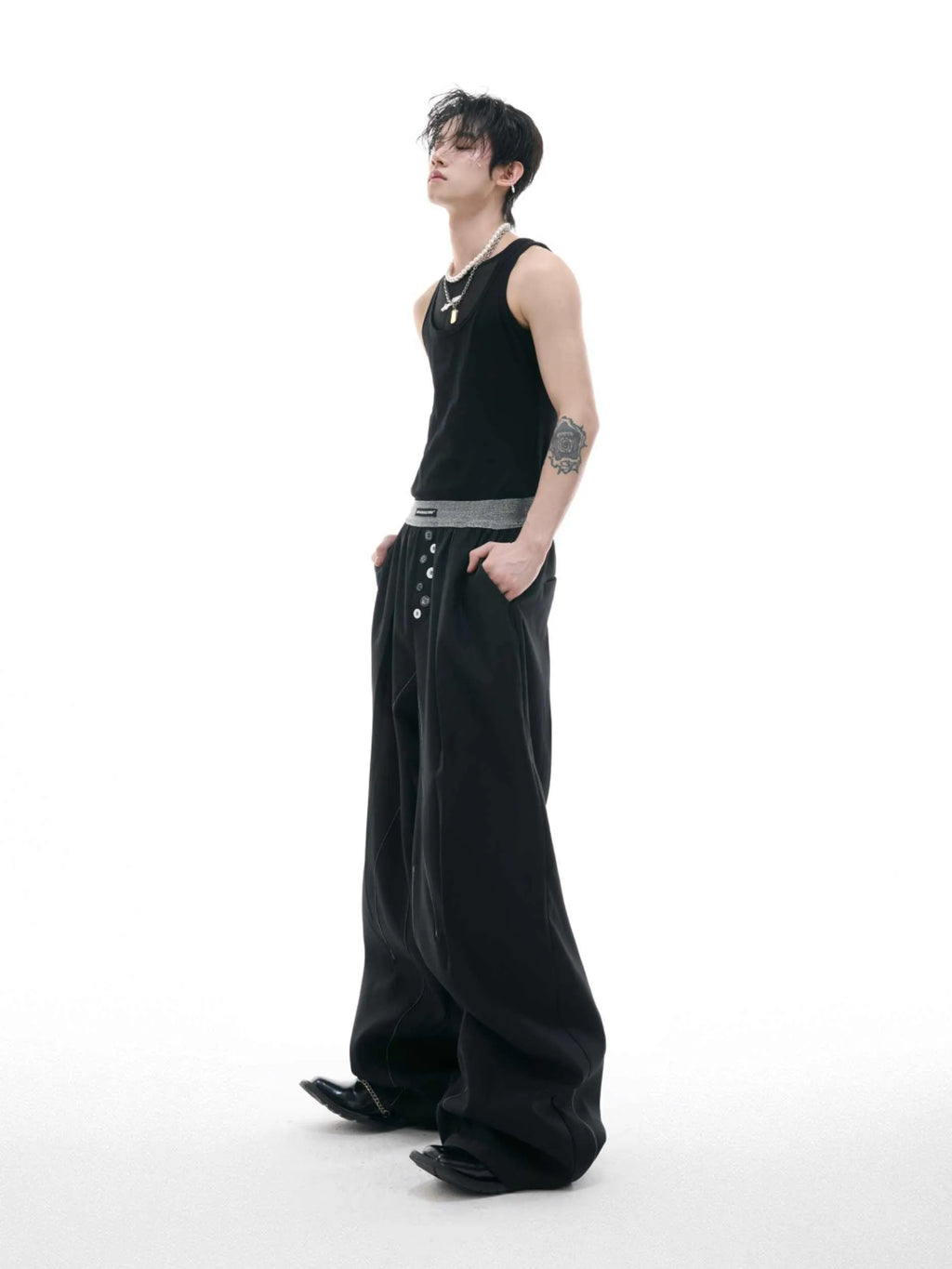 Men's straight-leg casual trousers with drooping design and button detail in black or grey