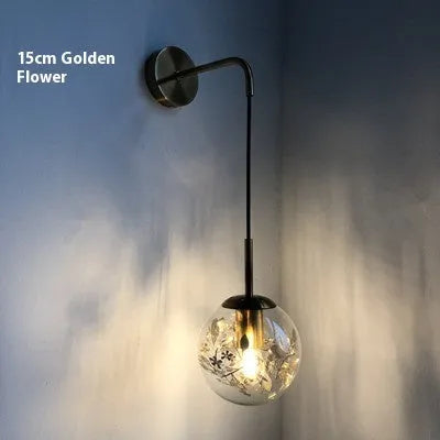 Modern glass wall lamp with golden flower pattern, 20cm size, emitting warm LED light.