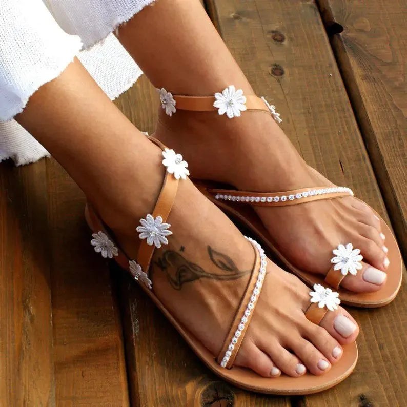 Brown flat beach sandals with herringbone toe design and floral pattern on the artificial PU upper.