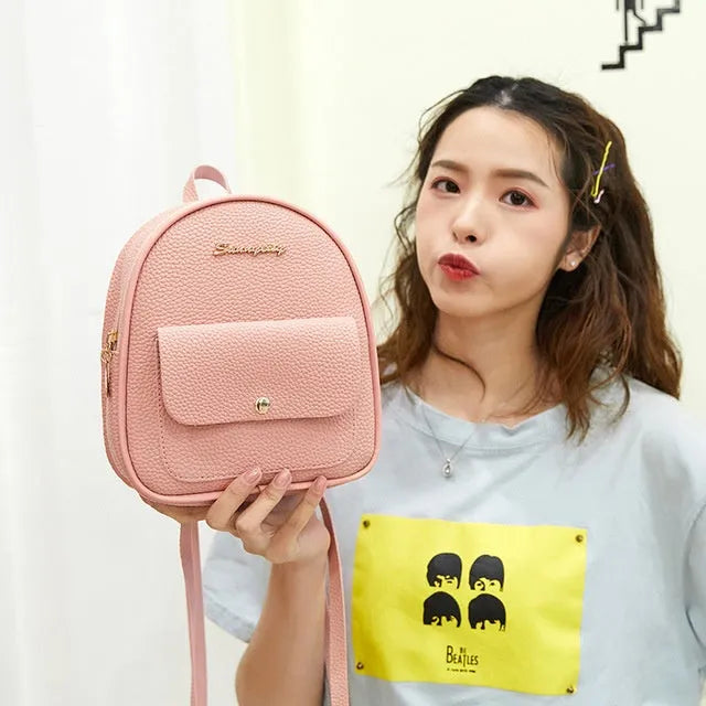 Small black PU women's backpack with zip closure shown as shoulder bag and backpack