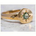 Gold-colour adjustable ring with a star-shaped design and oval asterism zircon.