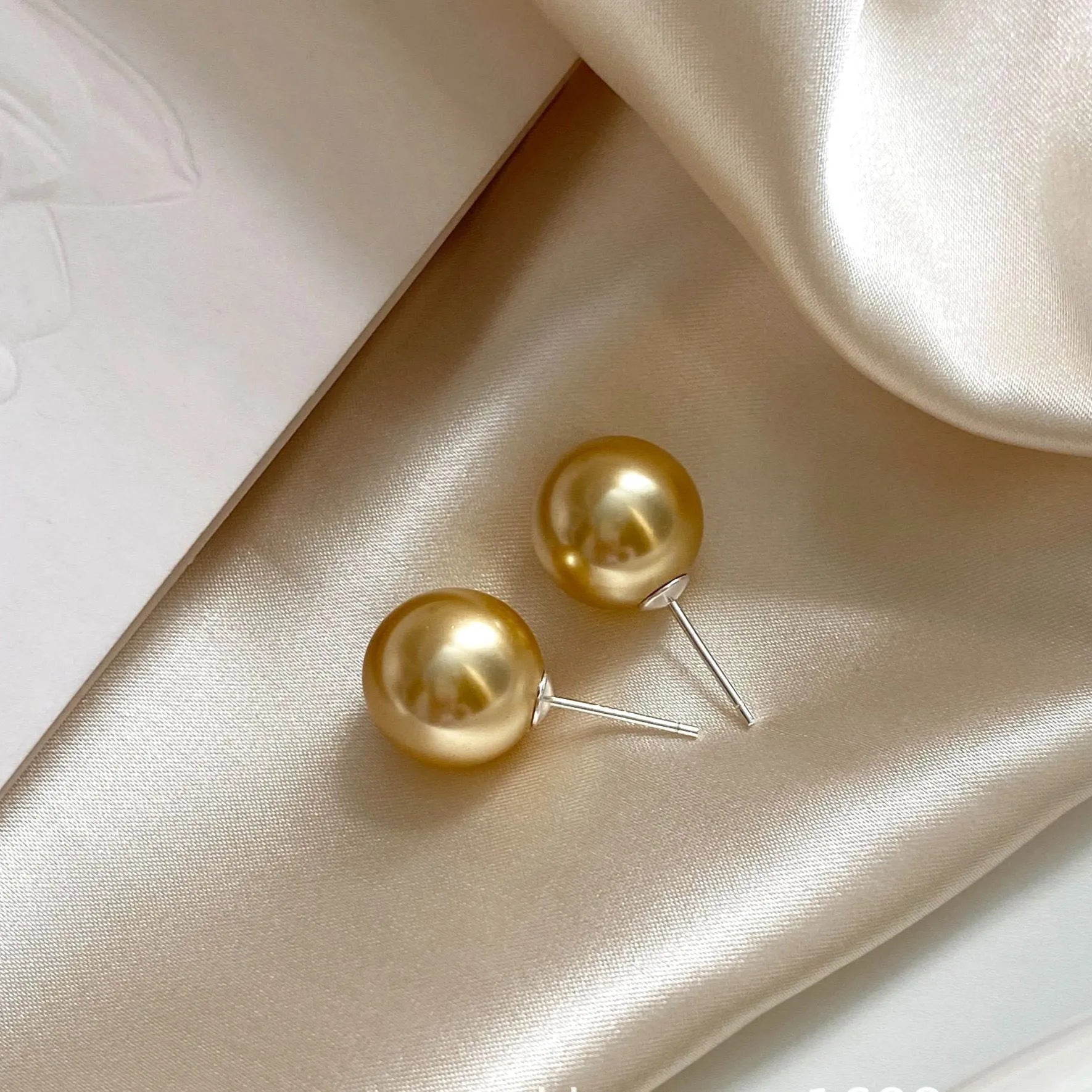Geometric pearl stud earrings with Awn star motifs in silver, showing size options