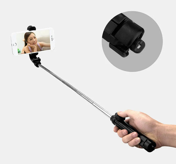 Bluetooth selfie stick tripod with remote control extended, showing adjustable phone clip in black colour.