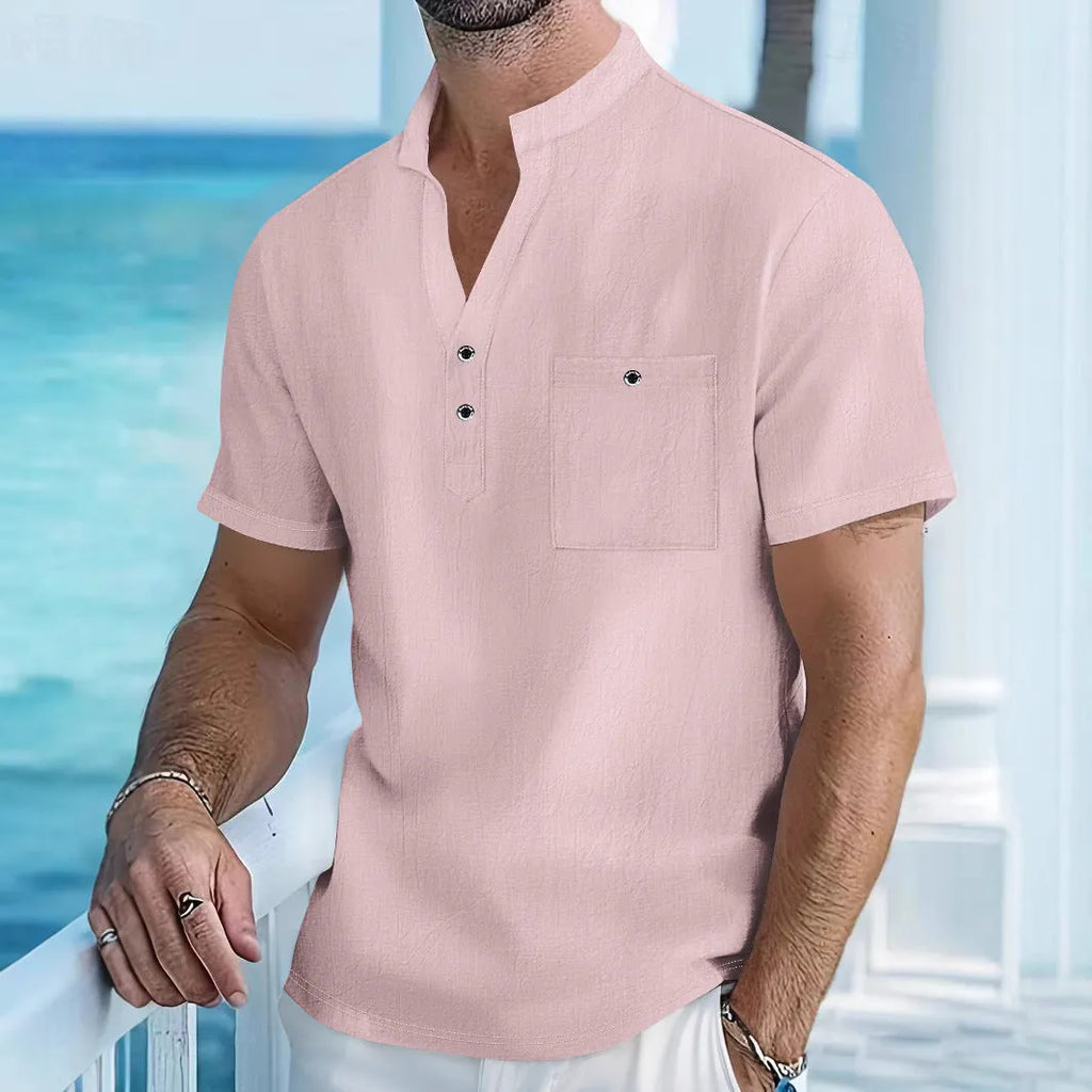 Man wearing a light apricot-coloured linen blend T-shirt with a stand collar and short sleeves.