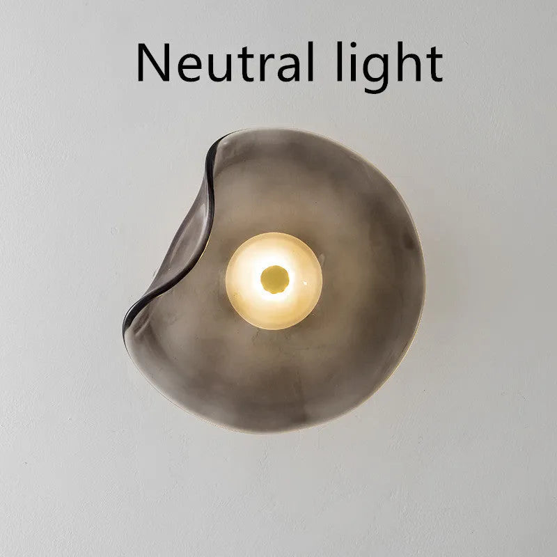 Round decorative wall lamp with glass shade in choice of cognac, light purple, or smoky grey finishes for bedroom lighting