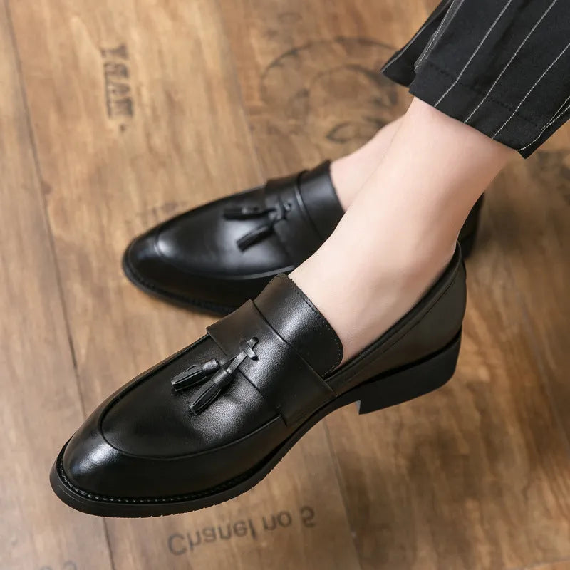 Men's black and brown tassel loafers with a slip-on design and rubber sole for business casual wear.