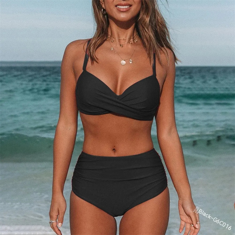 Women's black bikini with cross-back straps and briefs, laid flat