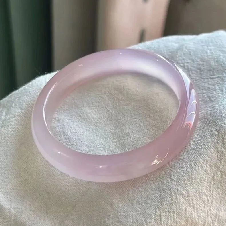 A natural agate wide tyre bracelet showing one of six colour options, such as pink or blue agate, on a wrist.