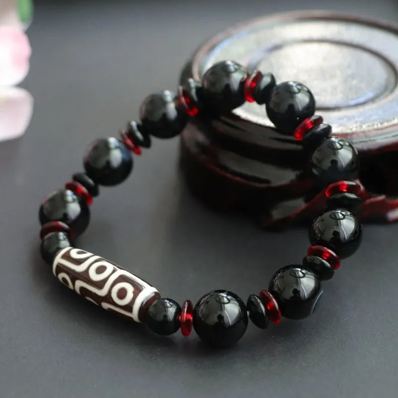 Black agate dzi bead bracelet with geometric beads and hand-woven construction