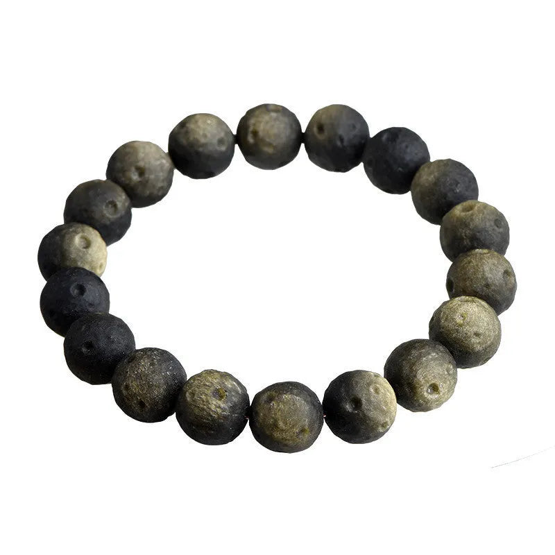 Natural obsidian crater ball bracelet showing textured beads in silver stone or golden obsidian colour on a wrist.