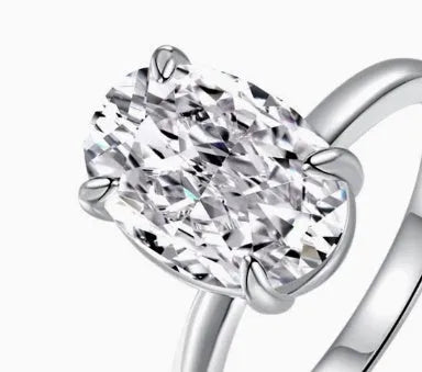 Oval women's ring with a four-claw setting on a silver band, showing gold and silver finish options.