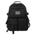 Black and white soft nylon student backpack showing external pockets and internal laptop compartment.