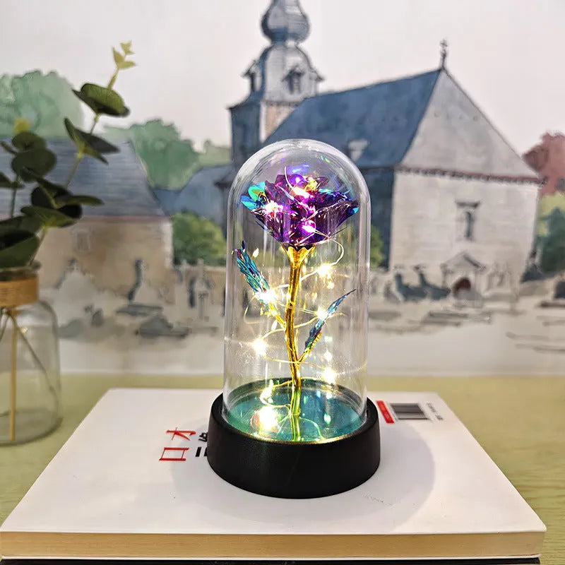 Small glass cover night lamp with plastic flower decoration showing warm golden light illumination