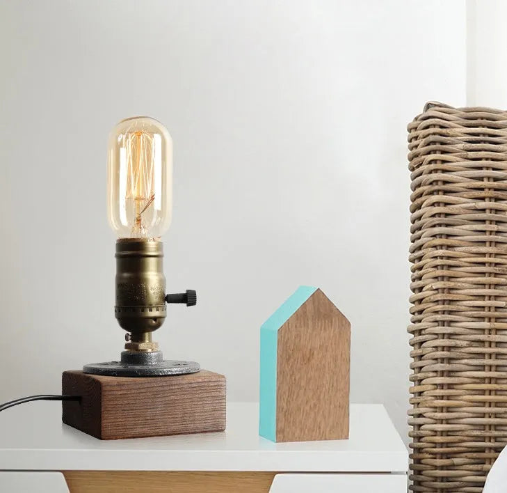 Wood and iron water pipe design table lamp measuring 9 cm wide by 13 cm high.