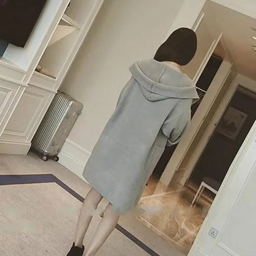 A plus-size woman wearing a loose grey cotton coat with lace details and long sleeves.