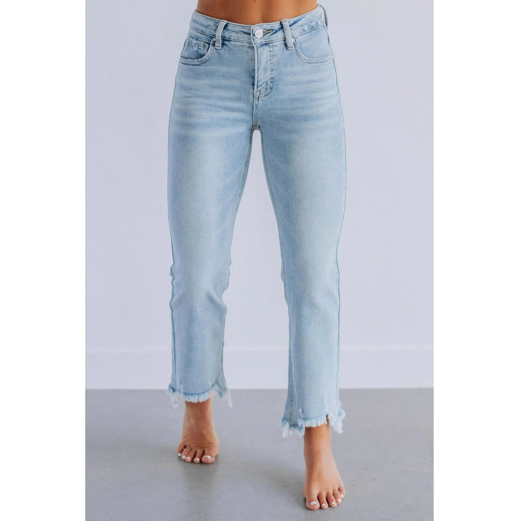 Women's solid colour denim jeans with hand-worn distressing in dark blue on a model