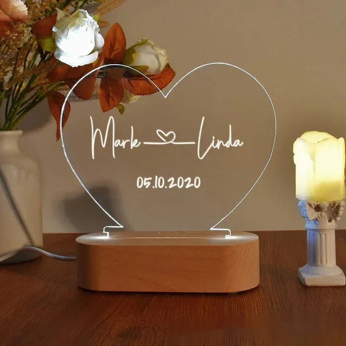 Custom engraved acrylic night light displaying personal names and a date, lit from a base LED.