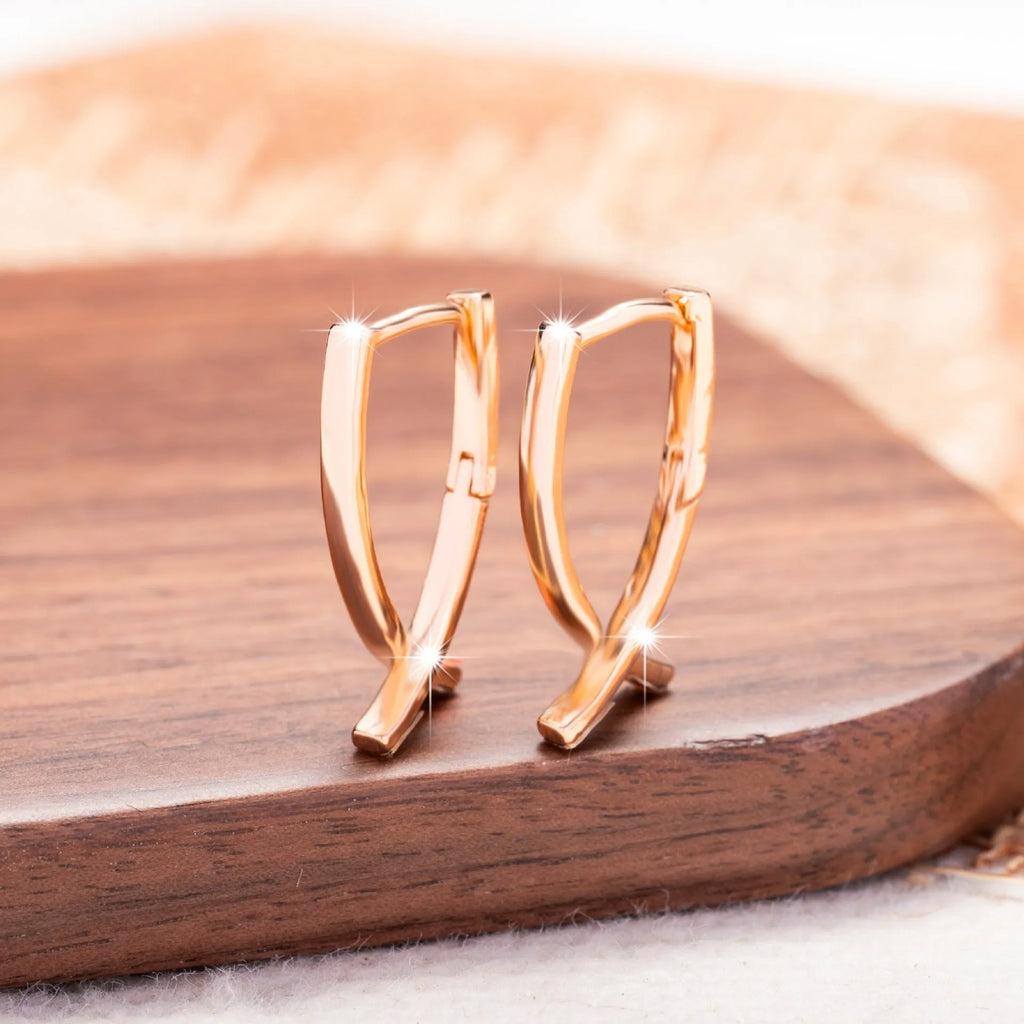 Single pair of rose gold cross shaped earrings made from copper with light luxury design