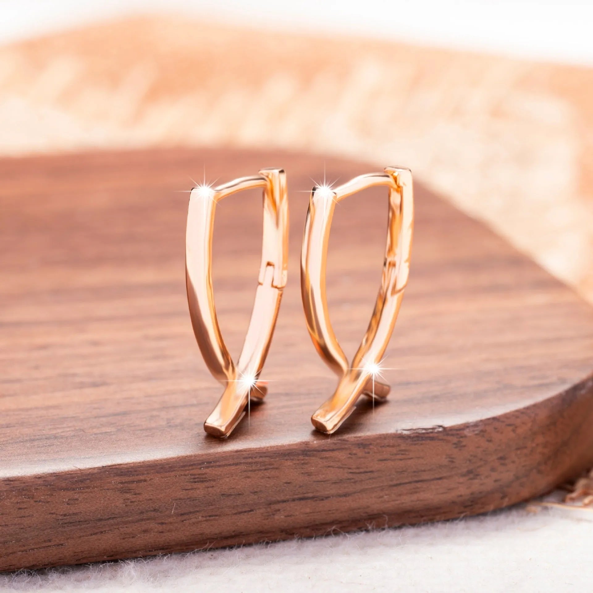 Single pair of rose gold cross shaped earrings made from copper with light luxury design