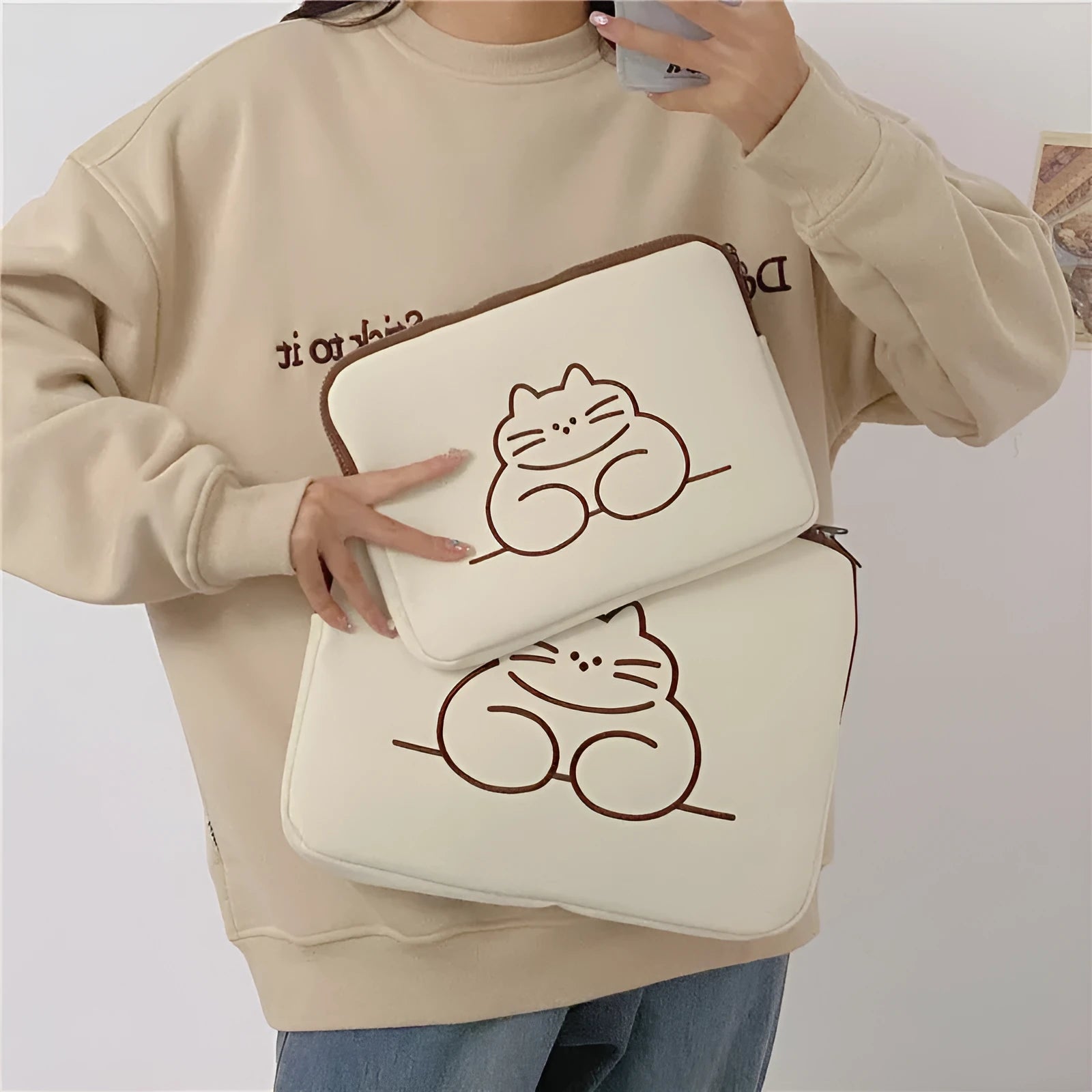 Nylon protective sleeve for tablet with embroidered fat cat design and zipper closure.
