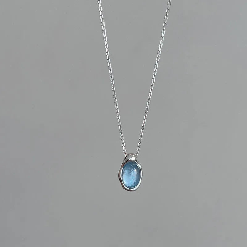 Navy blue water drop geometric pendant necklace with cross chain design on white background