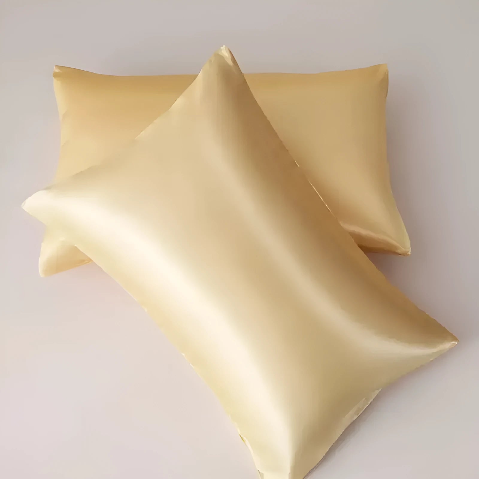 A pair of solid-colour polyester satin pillowcases in a selected shade, shown folded.