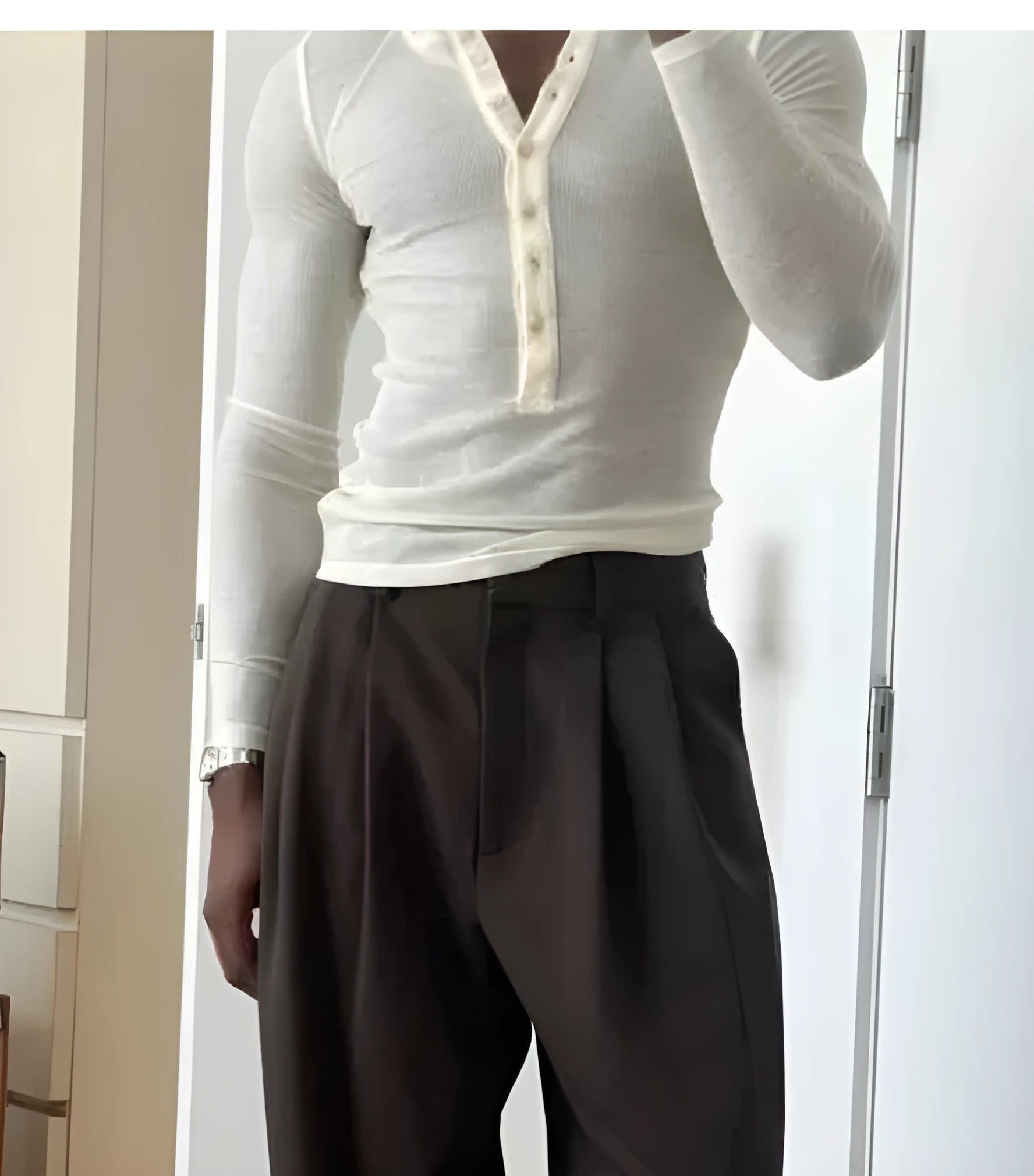 Man wearing a cream-coloured ribbed long-sleeve henley top with button-front detail.