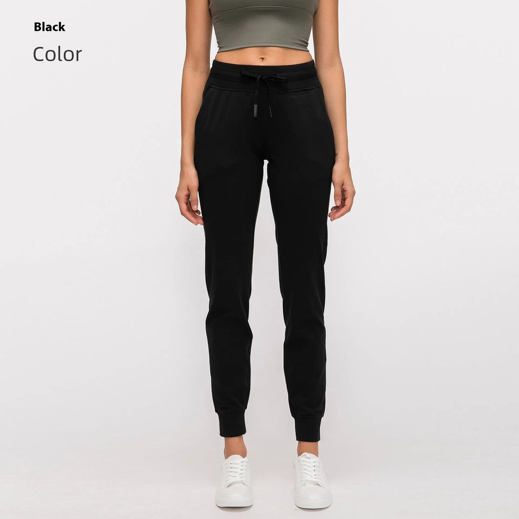 Women's high waist black yoga pants with drawstring detail, shown on a model.