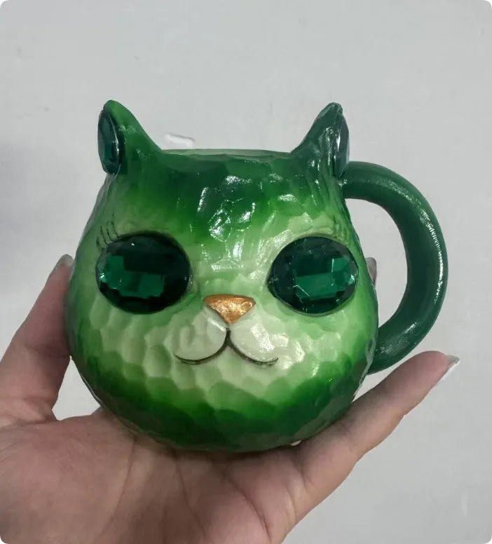 Purple, green, blue, and pink resin cat cup crystal earth craft ornament on display.