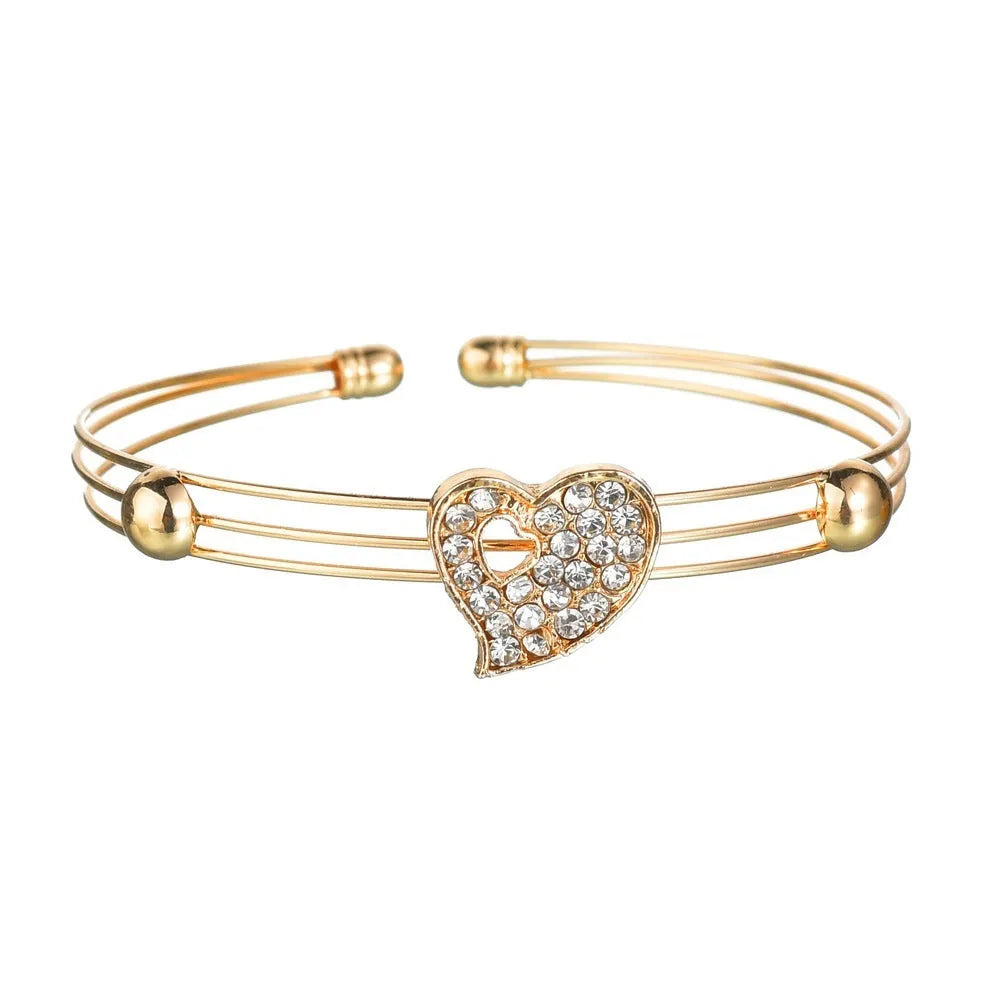 Gold colour women's jewellery set with earrings, pendant and adjustable bracelet featuring love, water drop and bell patterns
