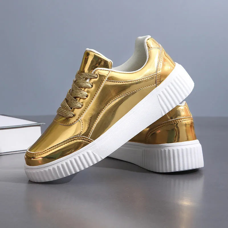 Gold sequinned platform sneakers with thick sole and round toe on a neutral background.