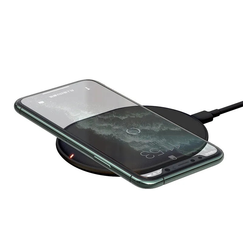 Baseus black wireless charging pad for mobile phones on a wooden surface