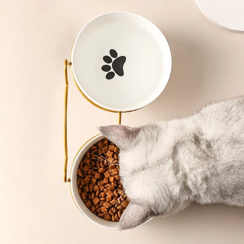 White ceramic cat bowl with decorative footprints in black iron frame with cat ear detailing