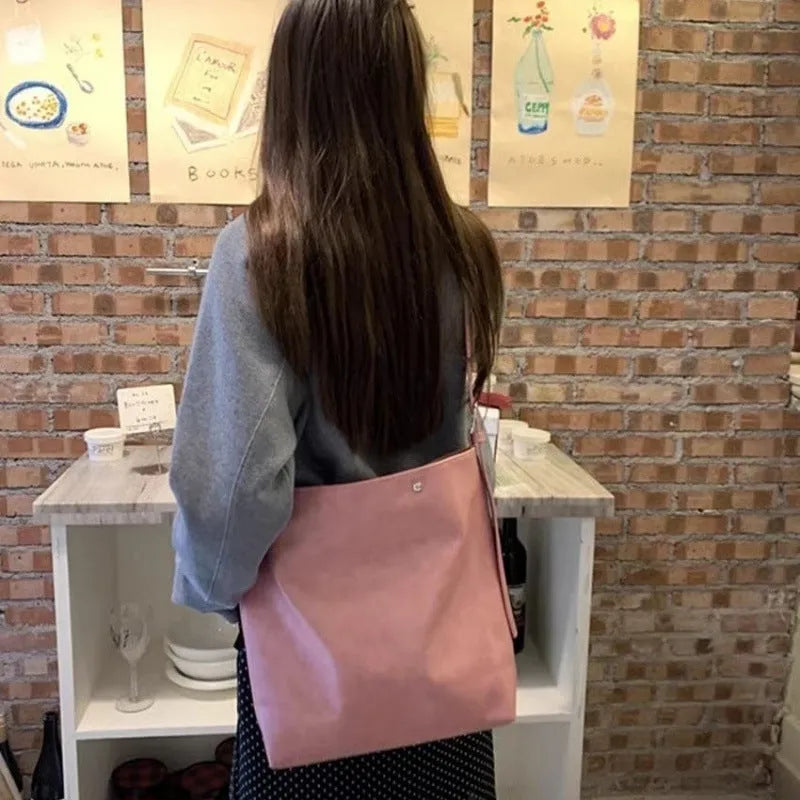 Corduroy single-shoulder commuter bag in pink with rectangular shape showing textured fabric