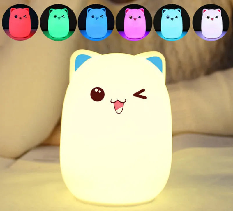 Cartoon silicone clap lamp in blue with warm white light mode on a wooden bedside table