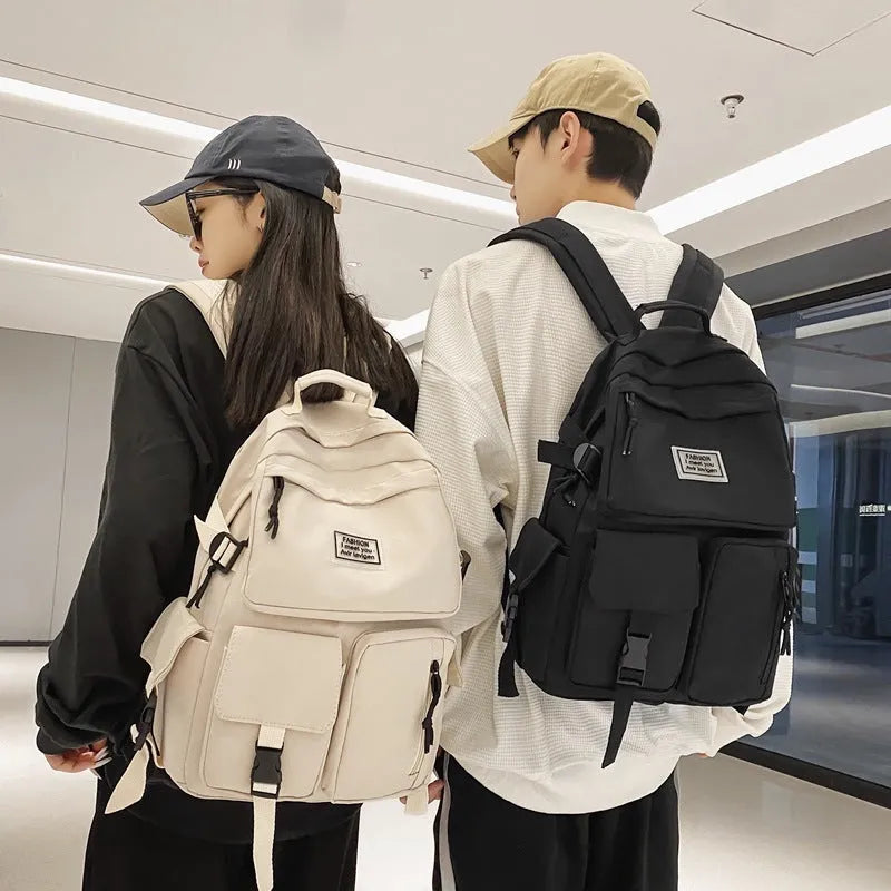 Black and white soft nylon student backpack showing external pockets and internal laptop compartment.