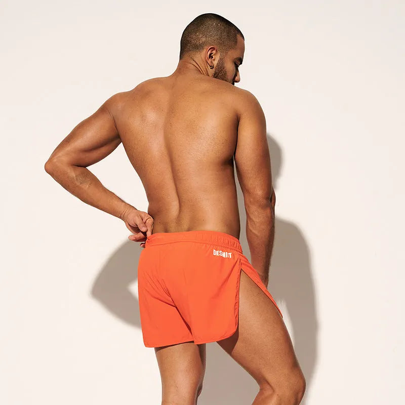 Men's loose orange, fluorescent green, or black polyester beach shorts on a size chart