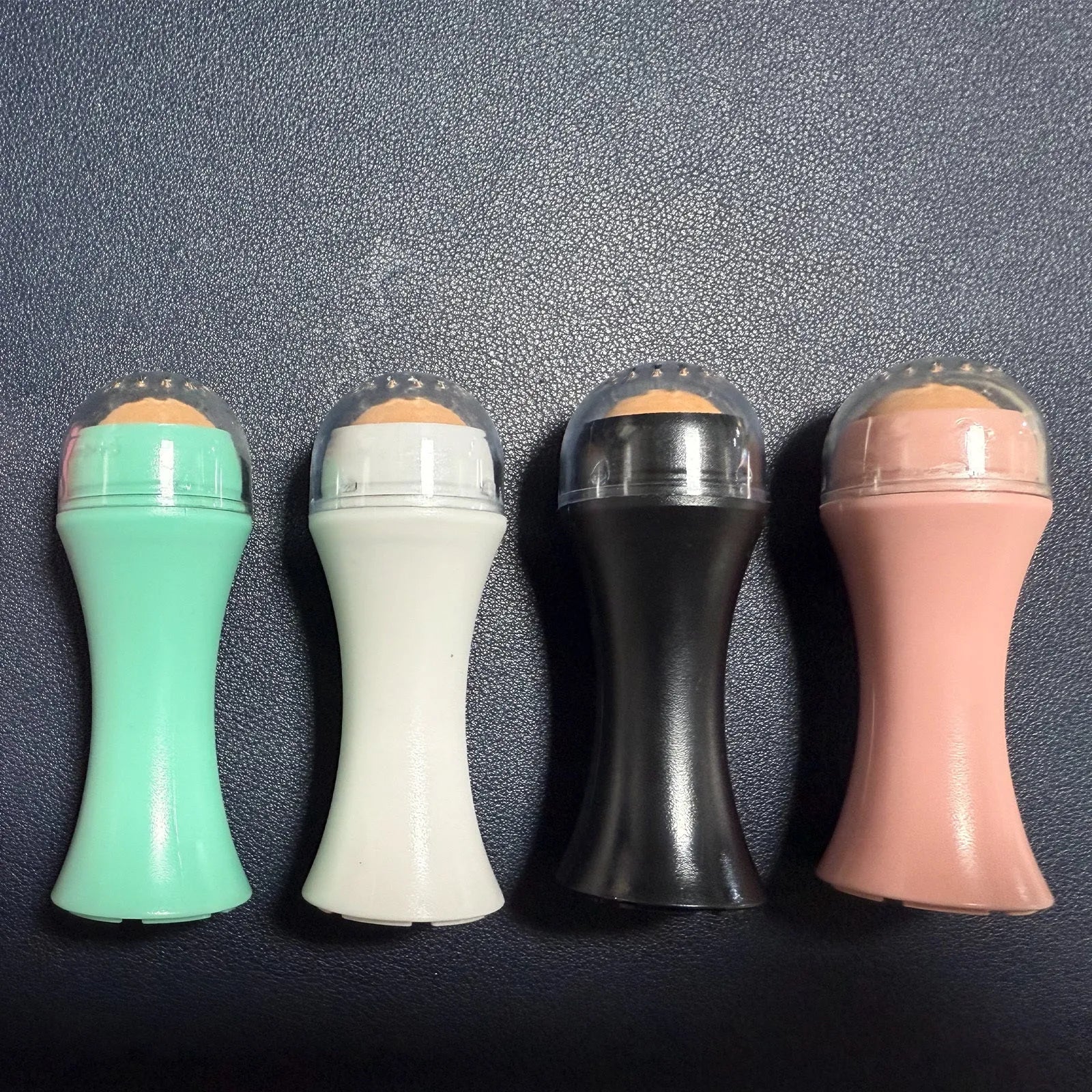 Portable mini volcanic stone roller for oily skin control in black, green, pink, or white