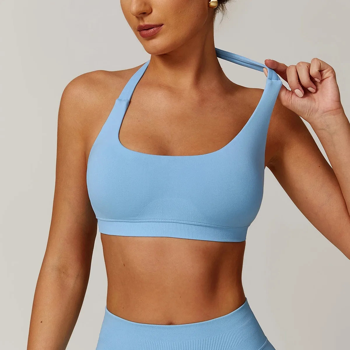 Women's black halter yoga bra with removable pads shown on a mannequin
