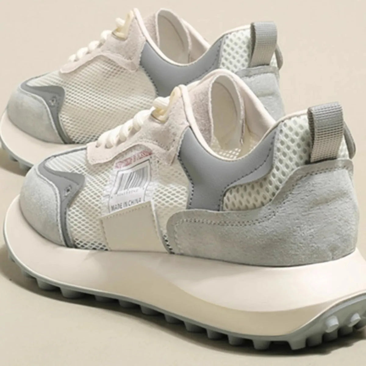 Women's pink and grey retro low-top sneaker with round toe and flat rubber sole.