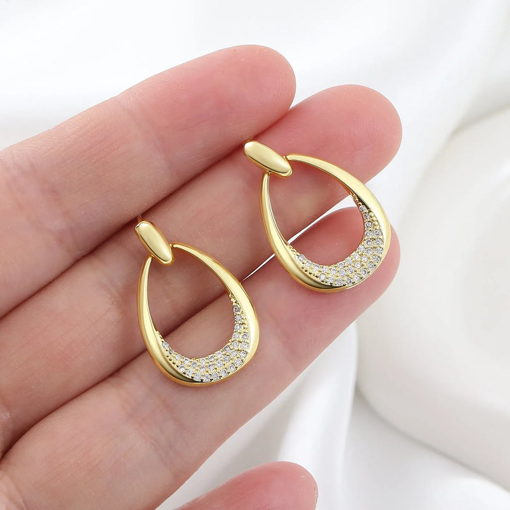 Yellow gold coloured geometric drop earrings for women, showing oval ring design.